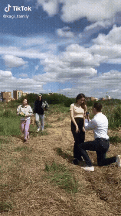 Man Kneeling To Propose To Woman In Field GIF