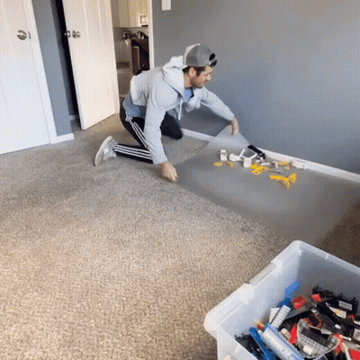 Man Kneeling With Box Of Lego Bricks GIF