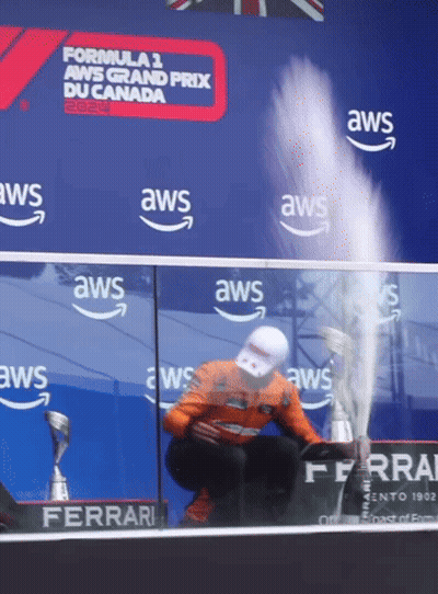 Man Kneeling With Trophy In Front Of AWS Banner GIF