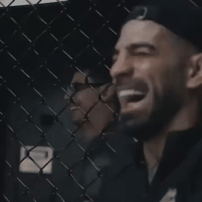Man Laughing Behind Chain Link Fence GIF