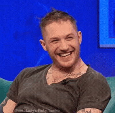 Man Laughing Sitting In Chair In Front Of Blue Wall GIF
