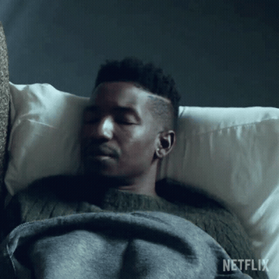 Man Laying In Bed With Netflix Blanket GIF