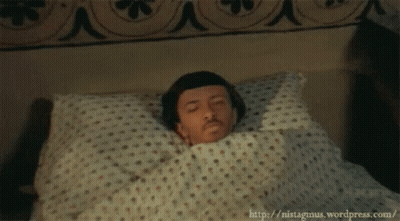 Man Laying In Bed With Polka Dot Blanket GIF