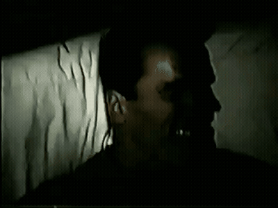 Man Laying In Dark Room With Mouth Open And Shadow GIF