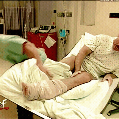 Man Laying In Hospital Bed With WWE Logo GIF