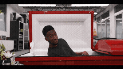 Man Laying In Red Coffin With Head Sticking Out GIF