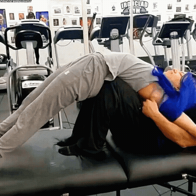 Man Laying On Another Man's Back At Iron Clad Gym GIF