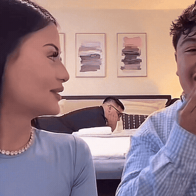 Man Laying On Bed Behind Woman GIF