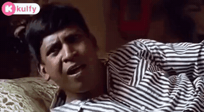 Man Laying On Bed In Striped Shirt Making Funny Face GIF