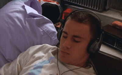 Man Laying On Bed With Headphones GIF