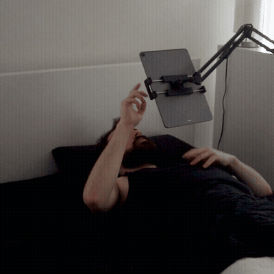 Man Laying On Bed With Tablet Holder On Head GIF