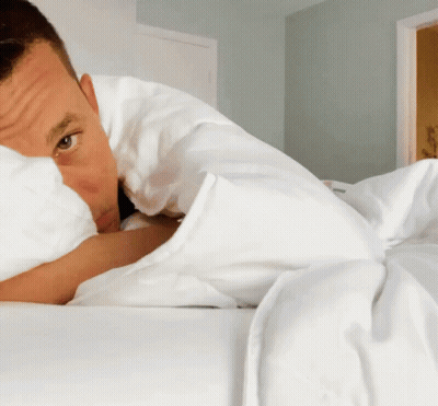 Man Laying On Bed With White Blanket GIF