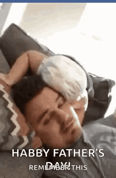 Man Laying on Couch With Baby Sleeping on Head