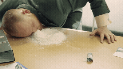 Man Laying On Desk With Powder On Floor GIF