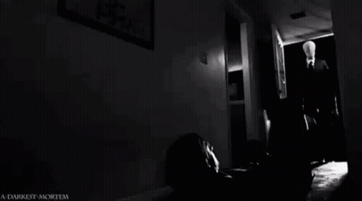 Man Laying On Floor In Dark Room With Slender Man GIF
