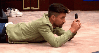 Man Laying On Floor Looking At Cell Phone GIF