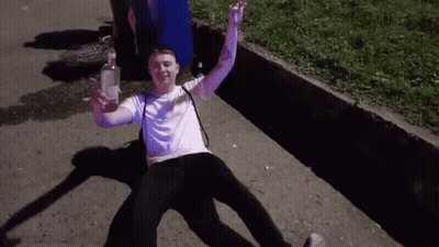 Man Laying On Ground With Vodka Bottle GIF