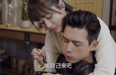 Man Laying On Woman's Lap With Headphones And Chinese Writing On Face GIF