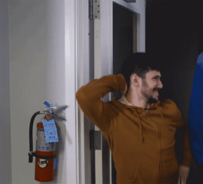 Man Leaning Against Door Near Fire Extinguisher 2019 GIF