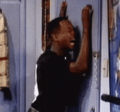 Man Leaning Against Door With Arms Up GIF