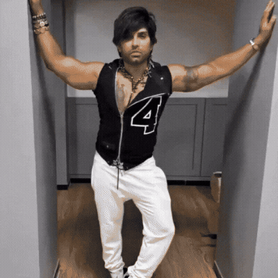 Man Leaning Against Wall In Black Shirt Number 4 GIF