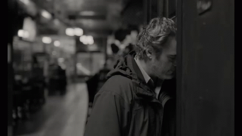 Man Leaning Against Wall With Head Down Black And White GIF