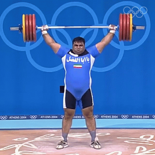 Man Lifting Barbell In Front Of Athens 2004 Signs GIF
