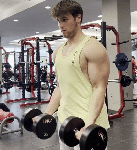 Man Lifting Dumbbells In Yellow Tank Top Saying Squatting GIF