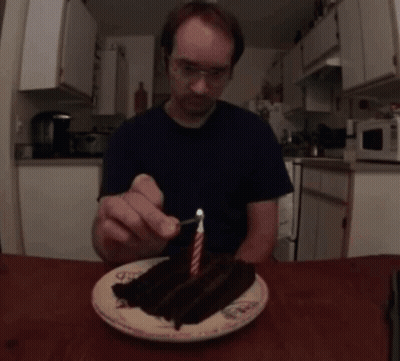 Man Lighting Candle On Cake GIF