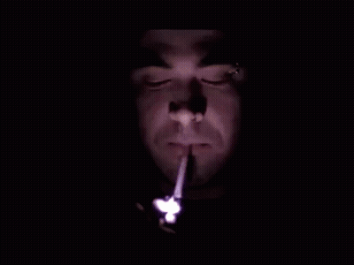 Man Lighting Cigarette In Dark With Lighter GIF