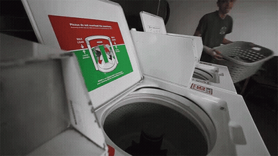 Man Loading Clothes Into Washing Machine Saying Please Do Not Overfill The Machine GIF