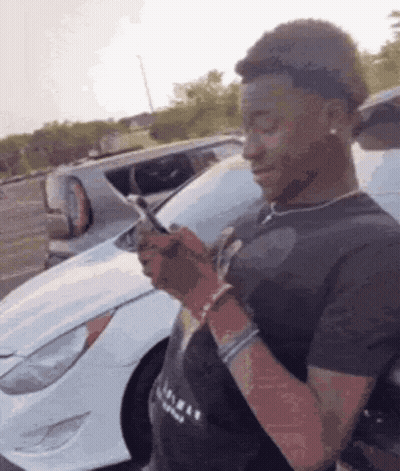 Man Looking At Cell Phone In Front Of White Car GIF