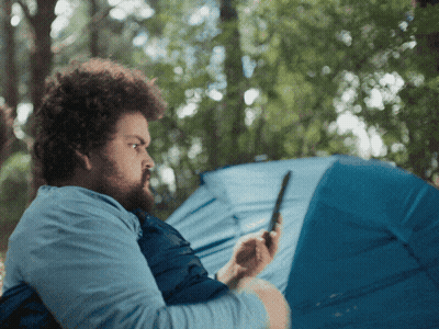 Man Looking At Phone By Blue Tent GIF
