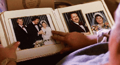 Man Looking At Photo Album With Bride And Groom GIF