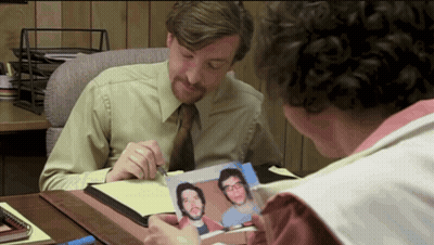 Man Looking At Picture Of Two Men GIF