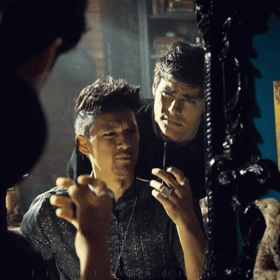 Man Looking At Reflection In Mirror Holding Lighter GIF