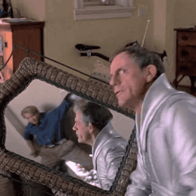 Man Looking At Reflection In Wicker Chair GIF