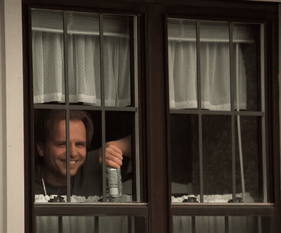 Man Looking Out Window Holding A Soda GIF