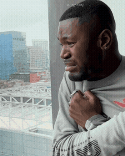 Man Looking Out Window With Scumchanify Watermark GIF