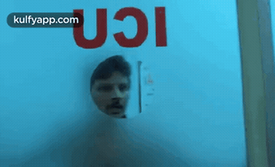 Man Looking Through Glass Door With UCI GIF