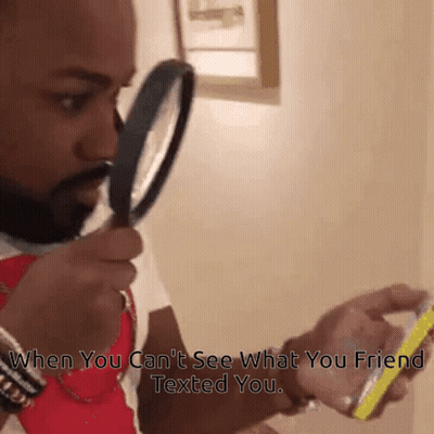 Man Looking Through Magnifying Glass At Phone GIF