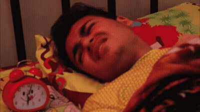 Man Lying In Bed Next To Red Alarm Clock GIF