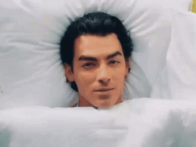 Man Lying In Bed Smiling GIF