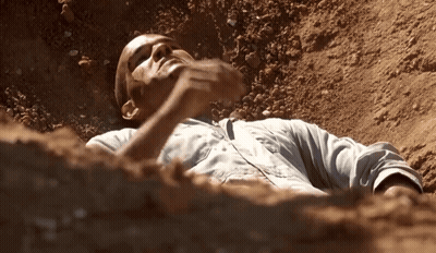 Man Lying In Dirt With Hand On Face GIF