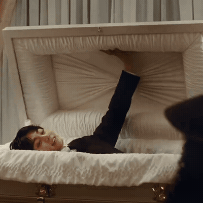 Man Lying In White Coffin Arm Outstretched GIF
