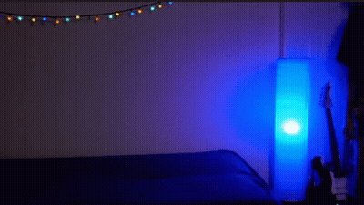 Man Lying On Another's Back In Dark Room With Blue Lamp GIF