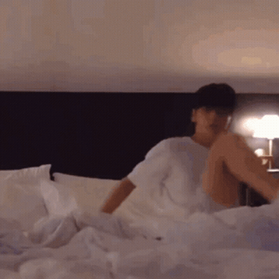Man Lying On Bed With Legs Crossed GIF