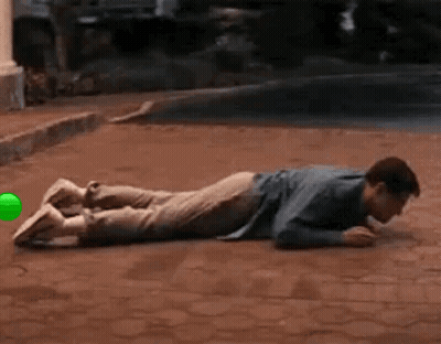 Man Lying On Brick Sidewalk With Green Ball GIF