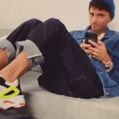 Man Lying On Couch Looking At Phone GIF