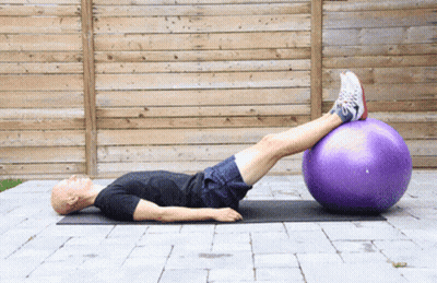Man Lying On Mat With Legs On Purple Ball GIF